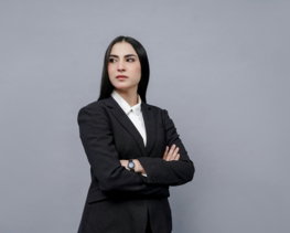 a woman in a business suit with her arms crossed